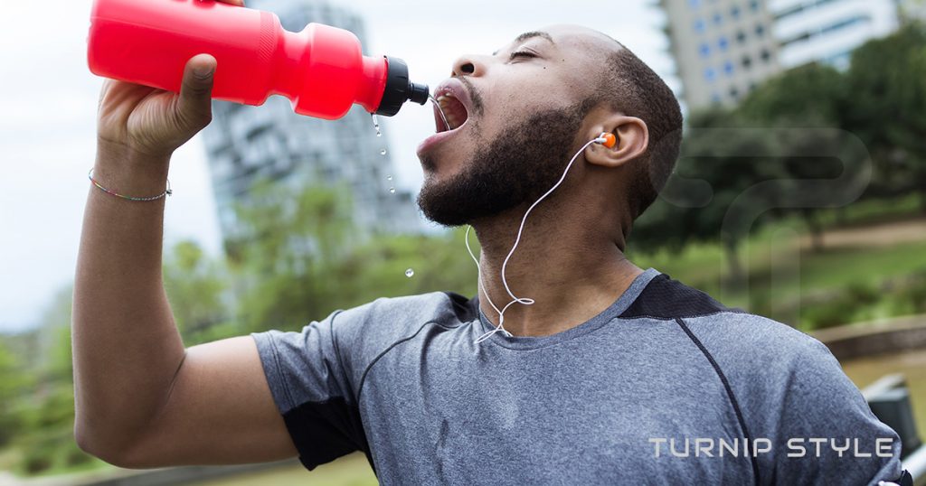 man drinking water after his work out