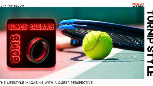 Black Cherry Bomb cockring displayed in front of tennis racquet on the ground in a tennis court