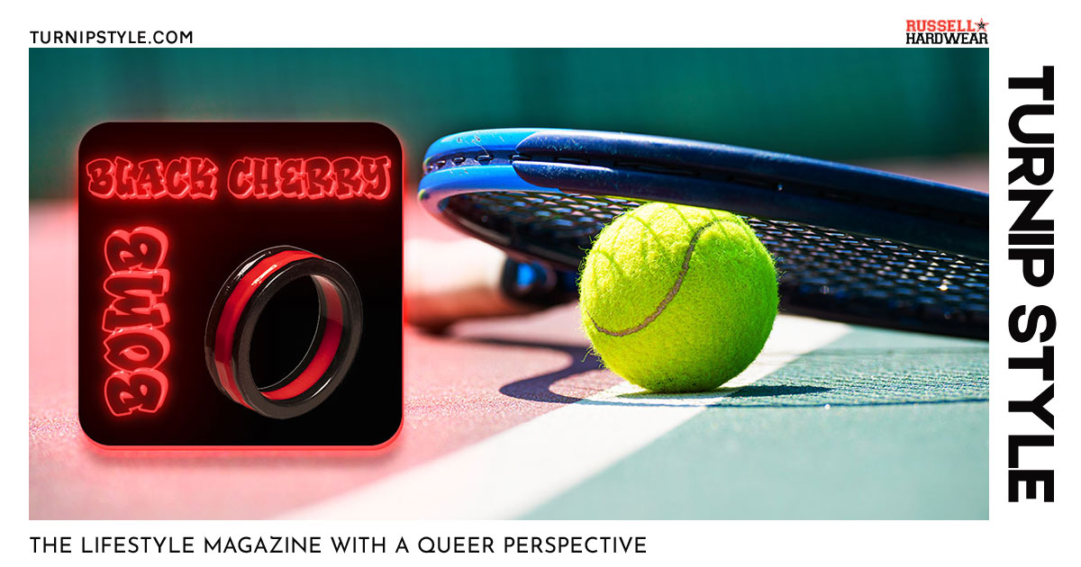 Black Cherry Bomb cockring displayed in front of tennis racquet on the ground in a tennis court